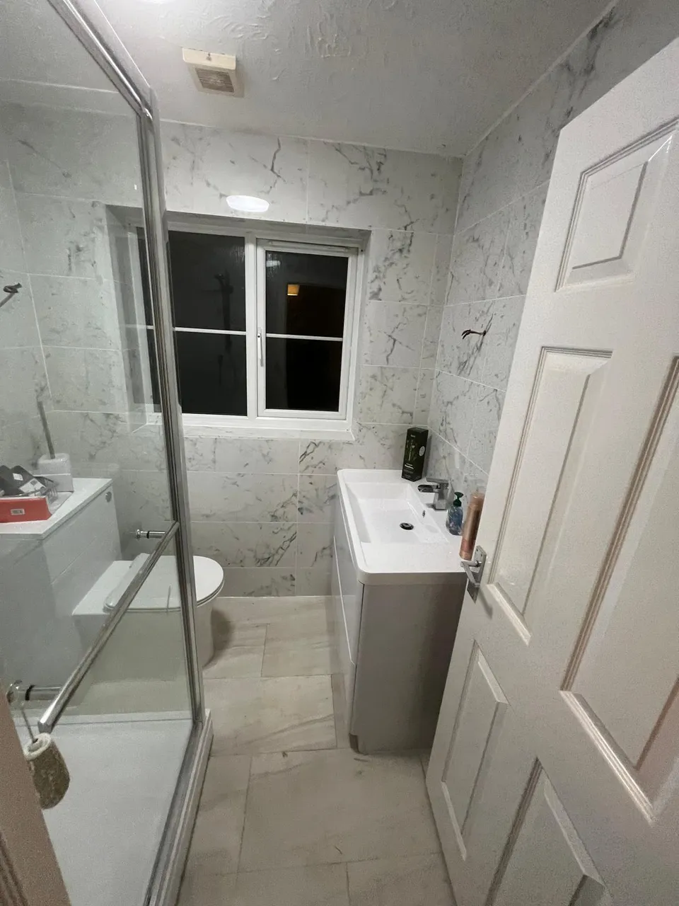 Shower room with glass enclosure and vanity unit seen from the doorway