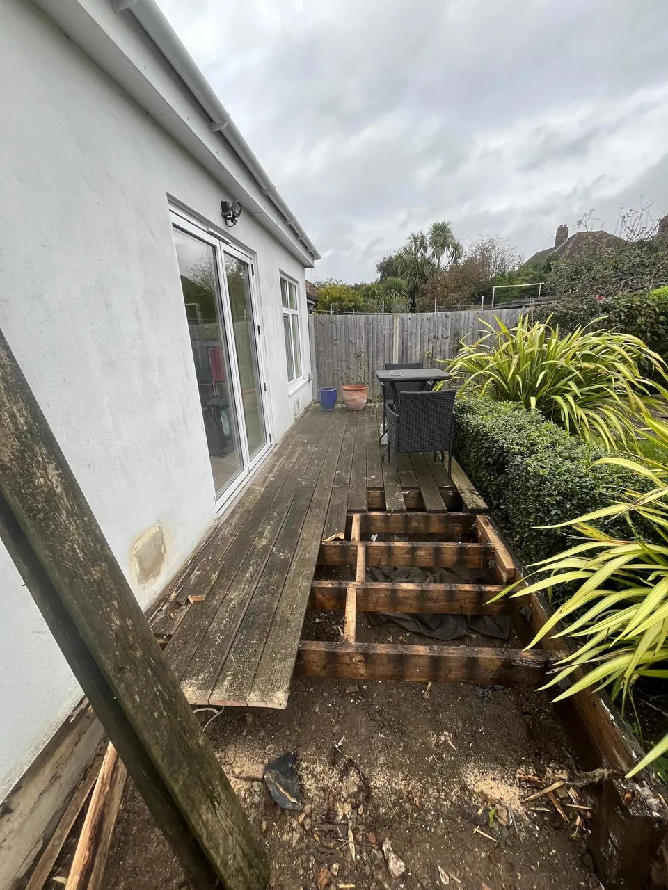 Old timber deck and steps being taken up beside the house